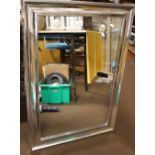 A SILVER COLOURED FRAMED MIRROR TOGETHER WITH A WOODEN FRAMED MIRROR