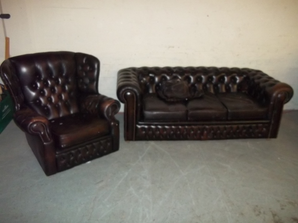 A BROWN LEATHER THREE SEATER CHESTERFIELD SOFA AND WING BACKED CHAIR (TWO PIECE SUITE)