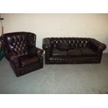 A BROWN LEATHER THREE SEATER CHESTERFIELD SOFA AND WING BACKED CHAIR (TWO PIECE SUITE)