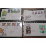 AN ALBUM OF POST OFFICE FIRST DAY COVERS, TOGETHER WITH THREE COMMEMORATIVE COINS AND STAMPS FIRST