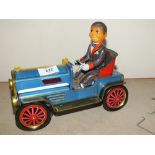 A VINTAGE BATTERY OPERATED TIN PLATE TOY MAN IN A CLASSIC CAR