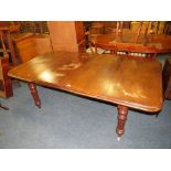 A VICTORIAN MAHOGANY WIND-OUT DINING TABLE WITH TWO EXTRA LEAVES, RAISED ON TURNED SUPPORTS -