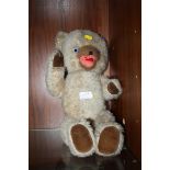 A VINTAGE JOINTED TEDDY BEAR WITH GLASS EYES AND PULL STRING