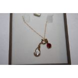 A 9 CARAT GOLD NECKLACE WITH TWO PENDANTS TO INCLUDE A RED GEM SET EXAMPLE