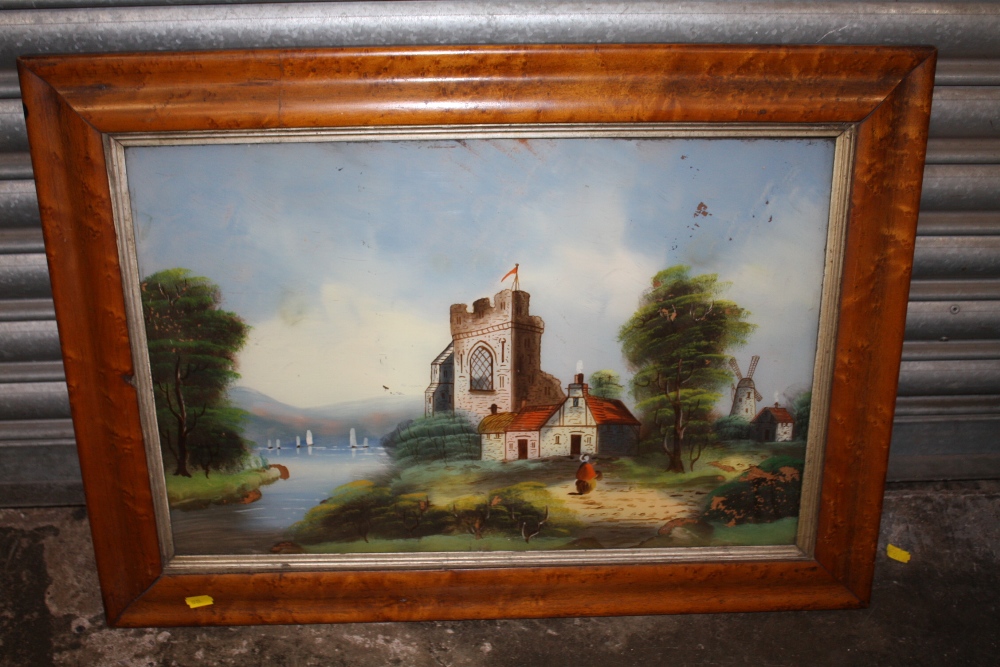 A SATINWOOD FRAMED REVERSE PAINTING ON GLASS DEPICTING A CHURCH BESIDE A RIVER A/F - SIZE 60CM X