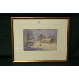 A FRAMED AND GLAZED WATERCOLOUR OF A FIGURE IN A COUNTRY LANDSCAPE WITH COTTAGES BY ROBERT MANN