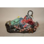 AN ORIENTAL CERAMIC RECLINING LADY HOLDING A BOOK