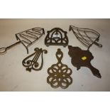 A COLLECTION OF BRASS AND OTHER IRON TRIVETS