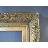 A 19TH CENTURY GOLD DECORATIVE FRAME WITH GOLD SLIP, frame W 12 cm, slip rebate 77 x 57 cm, frame