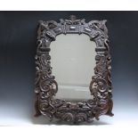 CIRCA 16TH CENTURY. Profusely carved oak frame with later silvered mirror plate, width of frame 12