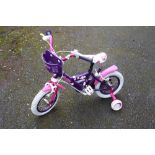 A SMALL CHILDS PURPLE BICYCLE