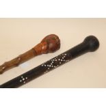 A VINTAGE EBONISED WALKING CANE WITH INLAID EMBELLISHMENT TOGETHER WITH ANOTHER EXAMPLE WITH A