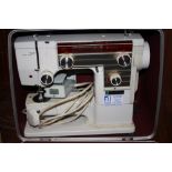 A CASED VINTAGE NEW HOME 609 ELECTRIC SEWING MACHINE