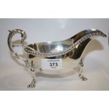 A HALLMARKED SILVER SAUCE BOAT TOGETHER WITH A PLATED LADLE