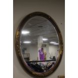 AN OVAL FRAMED MIRROR, APPROX. 78 X 54 CM