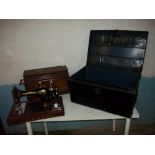 AN ANTIQUE SINGER SEWING MACHINE AND A METAL STORAGE / TRAVEL TRUNK