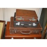 FOUR LEATHER TYPE SUITCASES