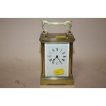 AN ANTIQUE BRASS AND GLASS CASED CARRIAGE CLOCK