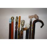 A COLLECTION OF MOSTLY MODERN WALKING STICKS AND CANES TO INCLUDE A SKULL TOPPED EXAMPLE, COMPASS