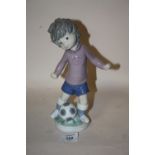 A LLADRO FIGURE OF A BOY WITH A FOOTBALL SPORT - BILLY PRODUCTIONS 1,978 HEIGHT - 23CM