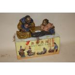 A BOXED AOYIMEITAO ORIENTAL CERAMIC FIGURE OF A MAN AND CHILD PLAYING CHECKERS