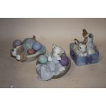 THREE NAO FIGURES OF RABBITS, A CAT AND A DOG IN BASKETS