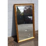 A LARGE CONTEMPORARY GILT FRAMED WALL MIRROR 70 X 128 CM