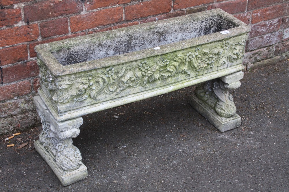 A RECTANGULAR GARDEN PLANTER WITH FLORAL DETAIL ON RAISED FEET