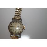 A LADIES OMEGA MANUAL WIND WRIST WATCH on an unbranded 9 ct gold strap, dedication inscription to