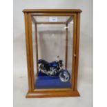 A GLASS DISPLAY CASE CONTAINING A MODEL HONDA MOTORBIKE