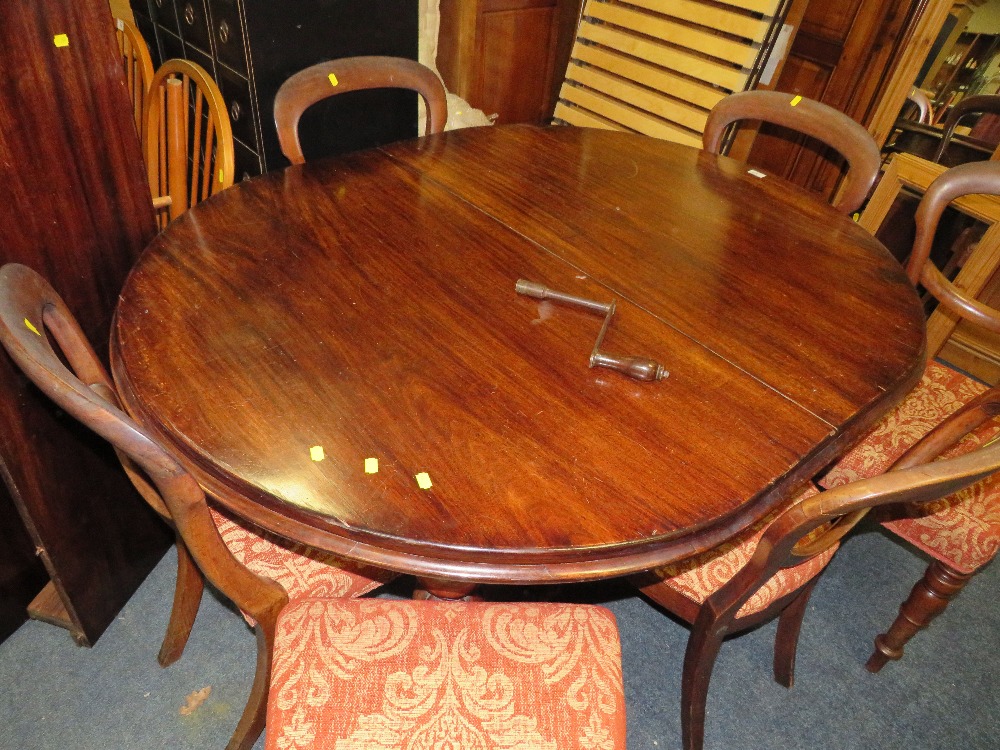 A LATE VICTORIAN MAHOGANY WIND-OUT DINING TABLE WITH TWO SPARE LEAVES RAISED ON FLUTED SUPPORTS -