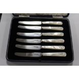 A CASED SET OF SIX HALLMARKED SILVER BLADED MOTHER OF PEARL HANDLED KNIVES APPROX WEIGHT -147.6G