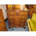 A 20TH CENTURY WALNUT CROSSBANDED SERPENTINE FRONTED FIVE DRAWER CHEST H-79 W-69 CM