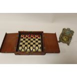 A VINTAGE MAHOGANY TRAVELLING CHESS SET TOGETHER WITH A VINTAGE GILT CLOCK