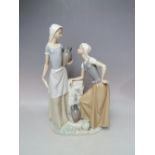 A LARGE NAO FIGURINE OF TWO LADIES COLLECTING WATER, H 39 cm, S/D