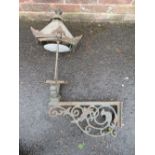 A CAST IRON EXTERIOR / COURTYARD LANTERN ON WALL BRACKET, with copper hood, approx. overall H 98 cm,