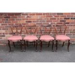 A SET OF FOUR VICTORIAN ROSEWOOD DINING CHAIRS, the shaped backs with scrolling supports, raised