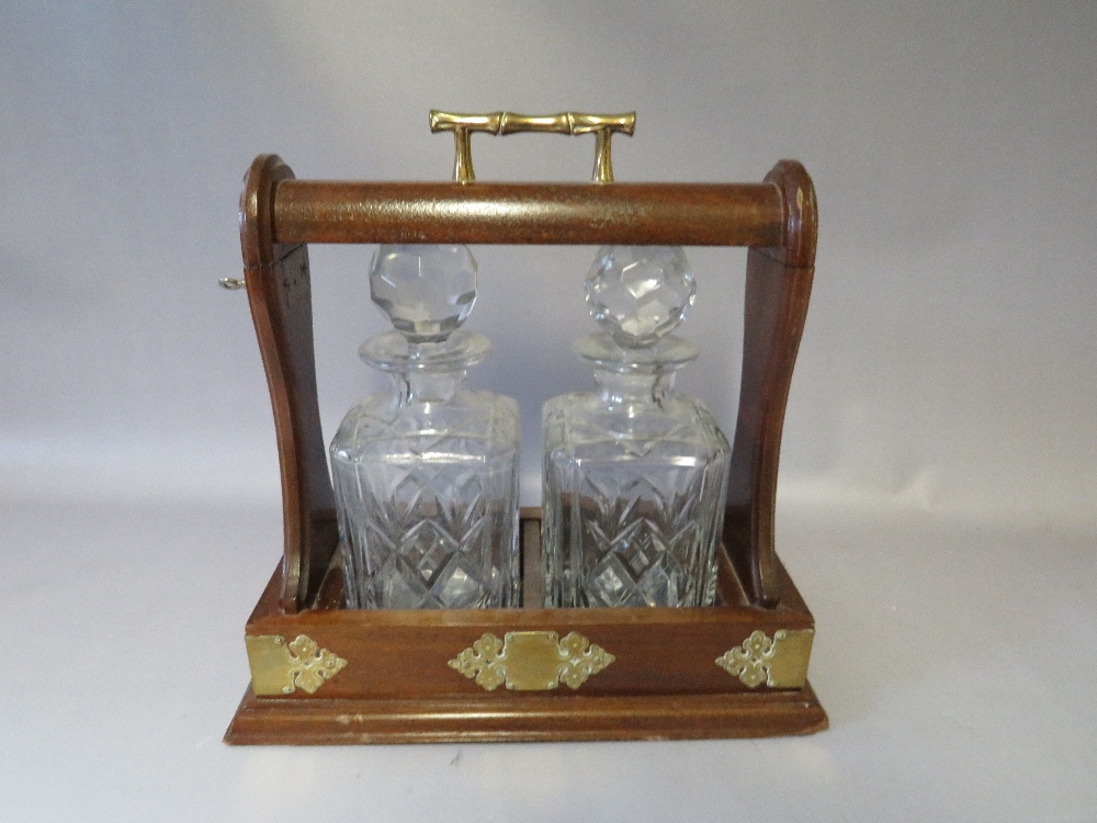 A TWENTIETH CENTURY MAHOGANY TWO DECANTER TANTALUS, with key, W 33 D 17 H 30 cm