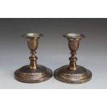 A DECORATIVE PAIR OF HALLMARKED SILVER CANDLESTICKS WITH WIDE BASE - LONDON 1961, having a filled