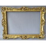 A 19TH CENTURY CARVED WOODEN DECORATIVE GILT SWEPT FRAME, frame W 7 cm, rebate 58 x 42 cm