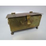 AN EARLY TWENTIETH CENTURY BRASS TABLE CASKET IN THE FORM OF A CHEST RAISED ON FOUR CLAW AND BALL