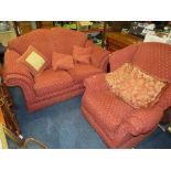 A MODERN RED UPHOLSTERED TWO PIECE LOUNGE SUITE AND A OTTOMAN (3)