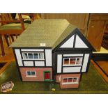 A VINTAGE DOLLS HOUSE IN A MOCK TUDOR STYLE WITH FURNITURE AND ELECTRICS H-54 CM W-55 CM