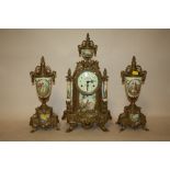 A MODERN BRASS AND CERAMIC CLOCK GARNITURE WITH FIGURATIVE DETAIL