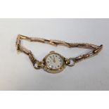 A 9 CARAT GOLD CASED ROTARY WRIST WATCH ON 9 CT EXPANDABLE STRAP