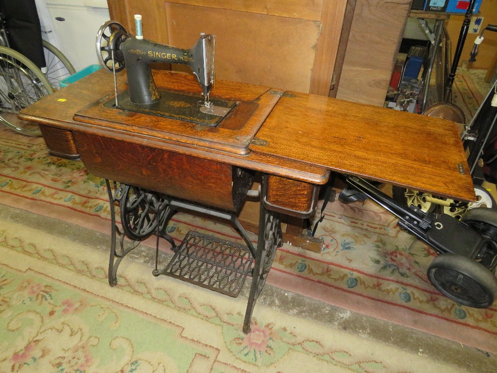 AN OAK AND CAST SINGER TREADLE SEWING MACHINE