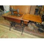 AN OAK AND CAST SINGER TREADLE SEWING MACHINE