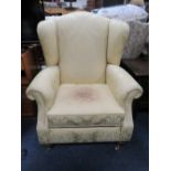 A MODERN UPHOLSTERED WING ARMCHAIR - A/F STAINED TO THE SEAT