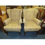 A PAIR OF TRADITIONALLY UPHOLSTERED WING ARMCHAIRS