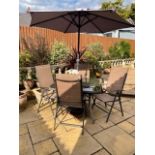 A GLASS TOPPED GARDEN TABLE WITH 4 CHAIRS AND A PARASOL IN USED CONDITION A/F